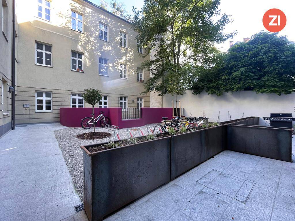 Gepflegter Innenhof mit Fahrradständern, Pflanzkübeln und einer ruhigen Atmosphäre.