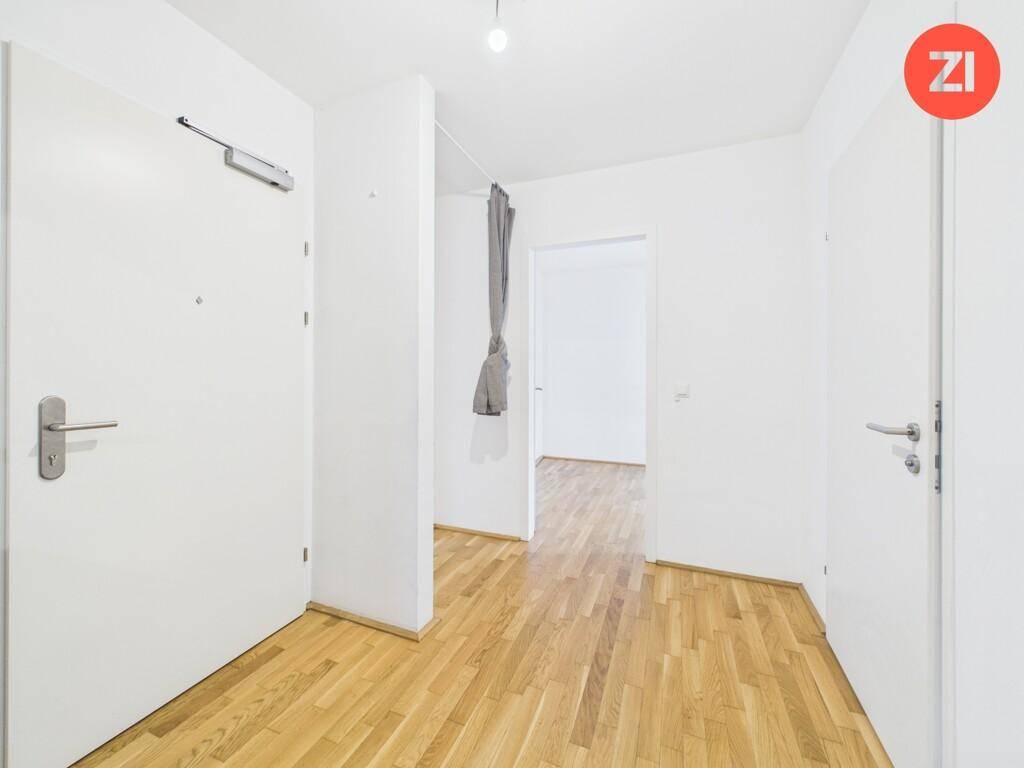 Heller Eingangsbereich mit Holzboden und Zugang zu verschiedenen Räumen der Wohnung.