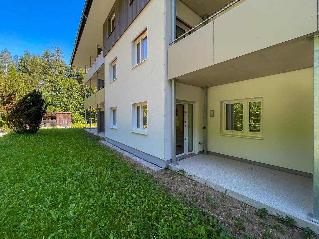 Erdgeschoss-Terrasse mit Zugang zum Garten, umgeben von grüner Natur.