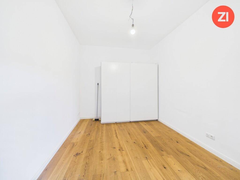 Leeres Schlafzimmer mit Holzboden und einem weißen Schrank, bereit zur individuellen Einrichtung.