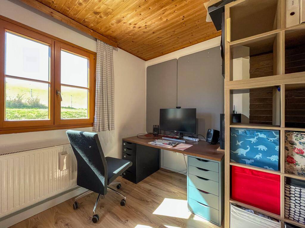 Helles Arbeitszimmer mit Holzboden, Schreibtisch und Blick ins Grüne, ideal zum Arbeiten.