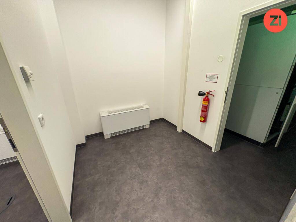 Kleiner Abstellraum mit Heizkörper und Feuerlöscher an der Wand.