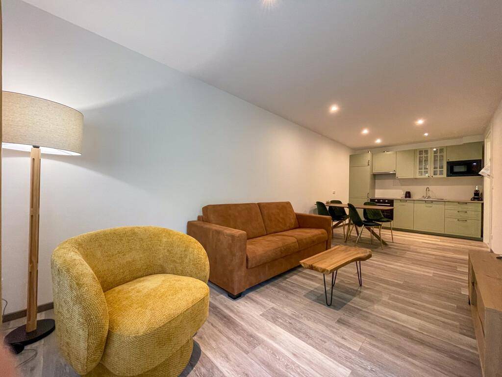 Offener Wohn- und Essbereich mit bequemen Sofas, Couchtisch und integrierter Küche.