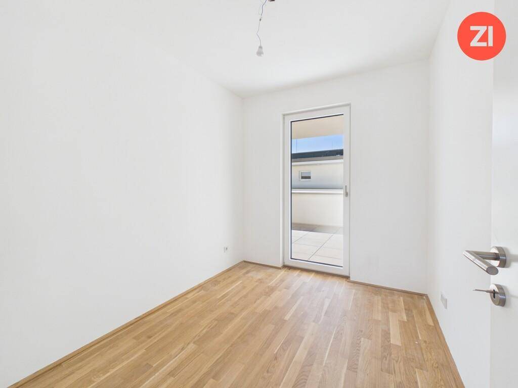 Helles Schlafzimmer mit Parkettboden und direktem Zugang zu einem Außenbereich.