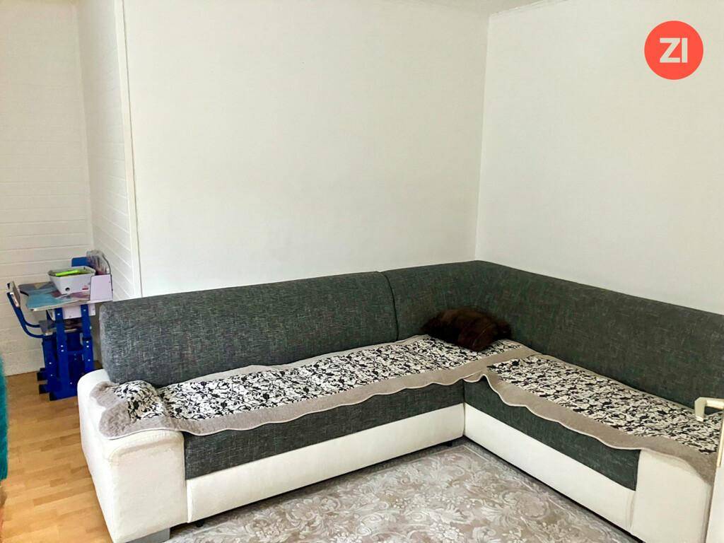 Wohnzimmer mit einem großen Ecksofa und einem Teppich, bietet Platz zum Entspannen.
