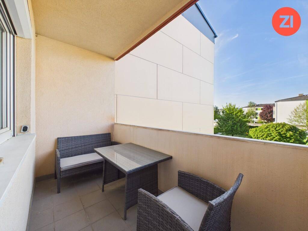Möblierter Balkon mit Sitzgelegenheiten und Blick auf die Umgebung.