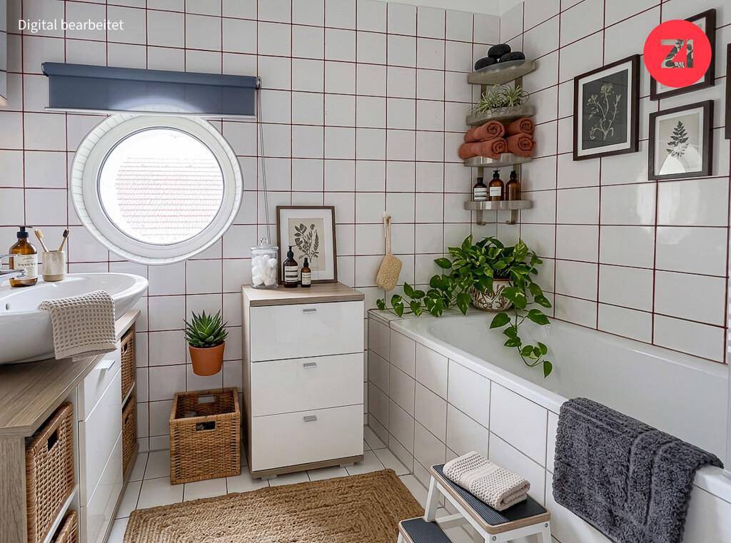 Modern inszeniertes Badezimmer mit Badewanne, Waschbecken und einem runden Fenster.