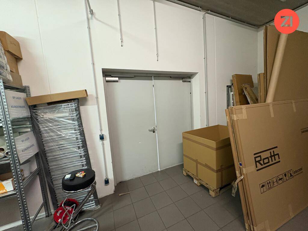 Lagerraum mit großen Kartons und einer breiten Doppeltür, ideal für Warenlieferungen.