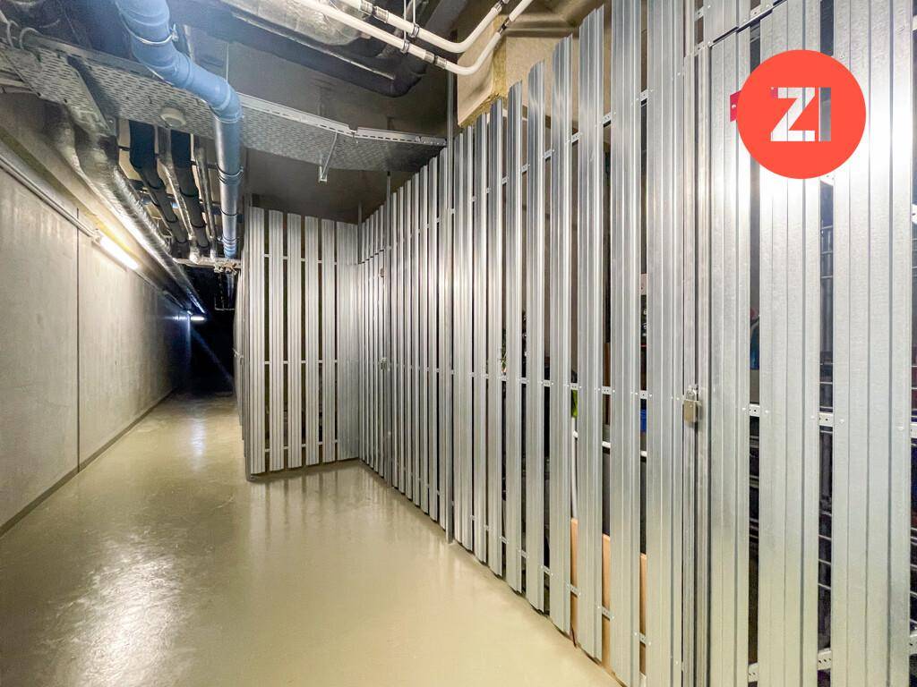 Kellerabteil mit Metallwänden und sichtbaren Rohren für zusätzlichen Stauraum.