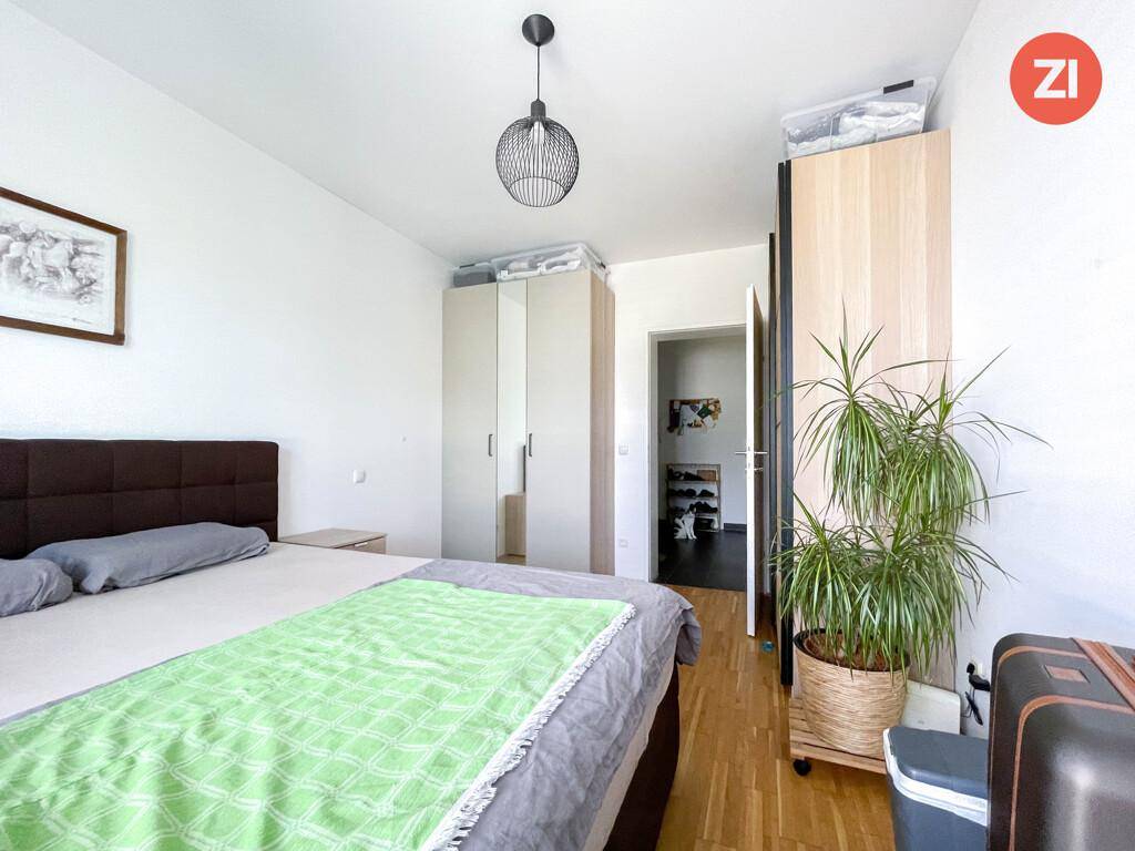 Schlafzimmer mit Holzboden, Kleiderschränken und Zugang zum Flur.