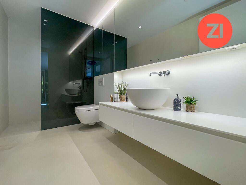 Modernes Badezimmer mit minimalistischem Design, schwebendem Waschtisch und begehbarer Dusche.