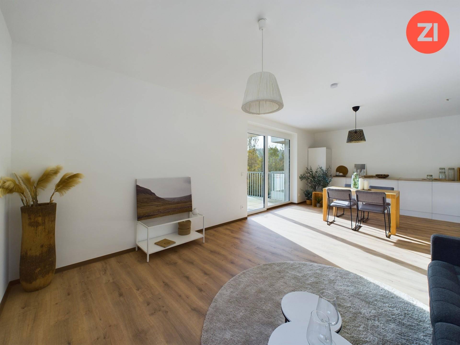 Geräumiger Wohnbereich mit Laminatboden, Zugang zum Balkon und moderner Dekoration.