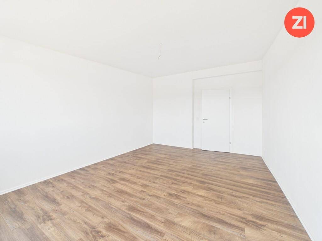 Unmöblierter Raum mit Laminatboden und weiß gestrichenen Wänden, ideal als Schlafzimmer.