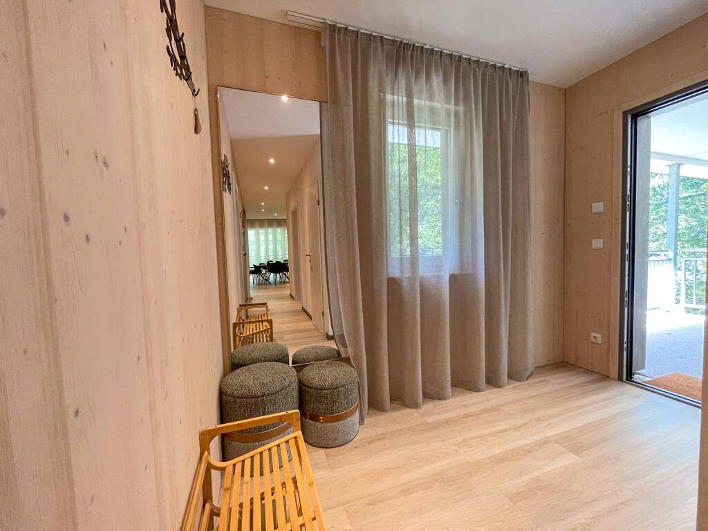 Heller Flur mit großem Spiegel, Vorhängen und Zugang zu einem Balkon oder einer Terrasse.