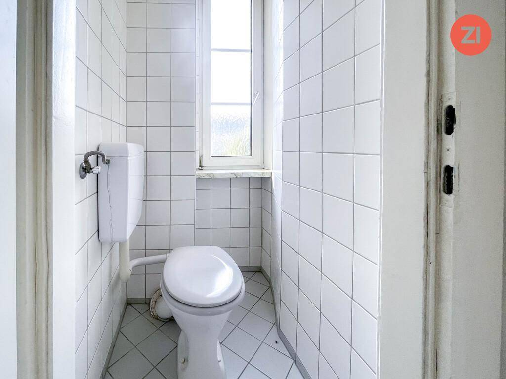 Separates WC mit Fenster, komplett gefliest und in gutem Zustand.