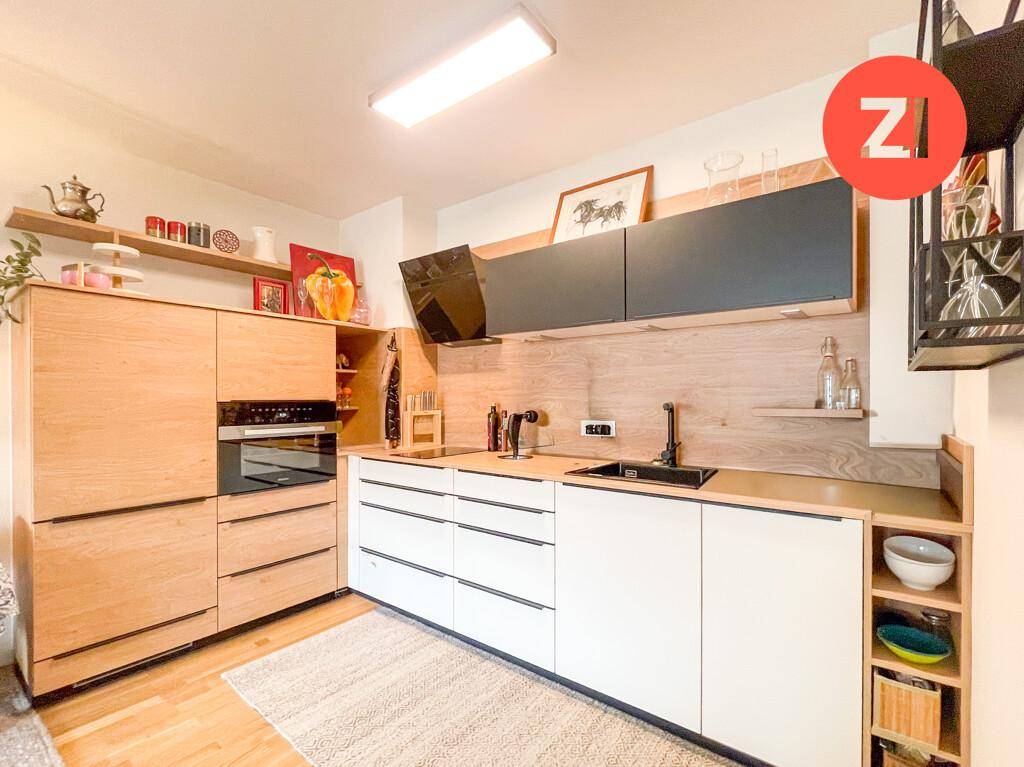 Gut ausgestattete moderne Küche mit Holz- und weißen Schränken sowie integrierten Geräten.