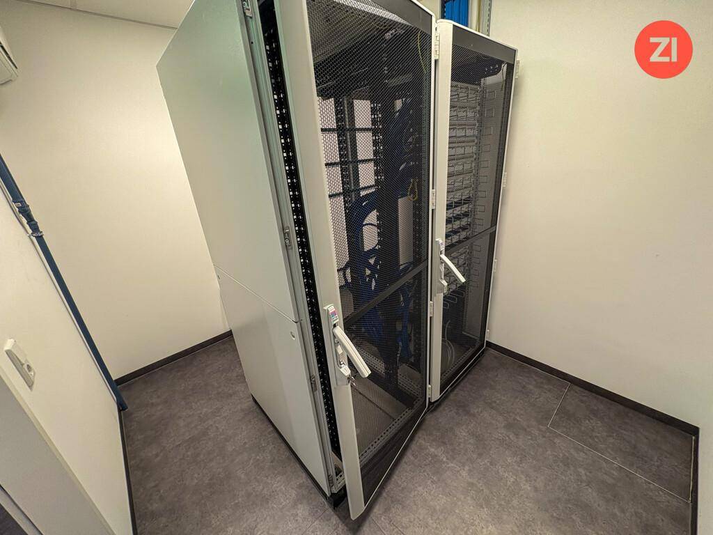 Serverraum mit zwei großen Serverschränken und technischer Ausstattung.