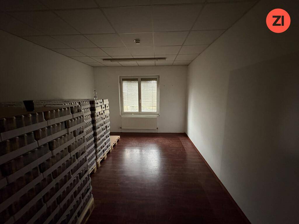 Lagerraum mit gestapelten Kartons und einem Fenster, das natürliches Tageslicht hereinlässt.