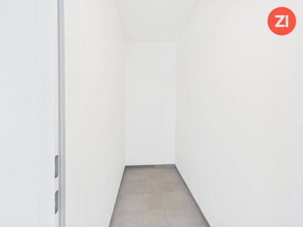 Schmaler, heller Flur mit Fliesenboden und weißen Wänden, verbindet verschiedene Räume der Wohnung.