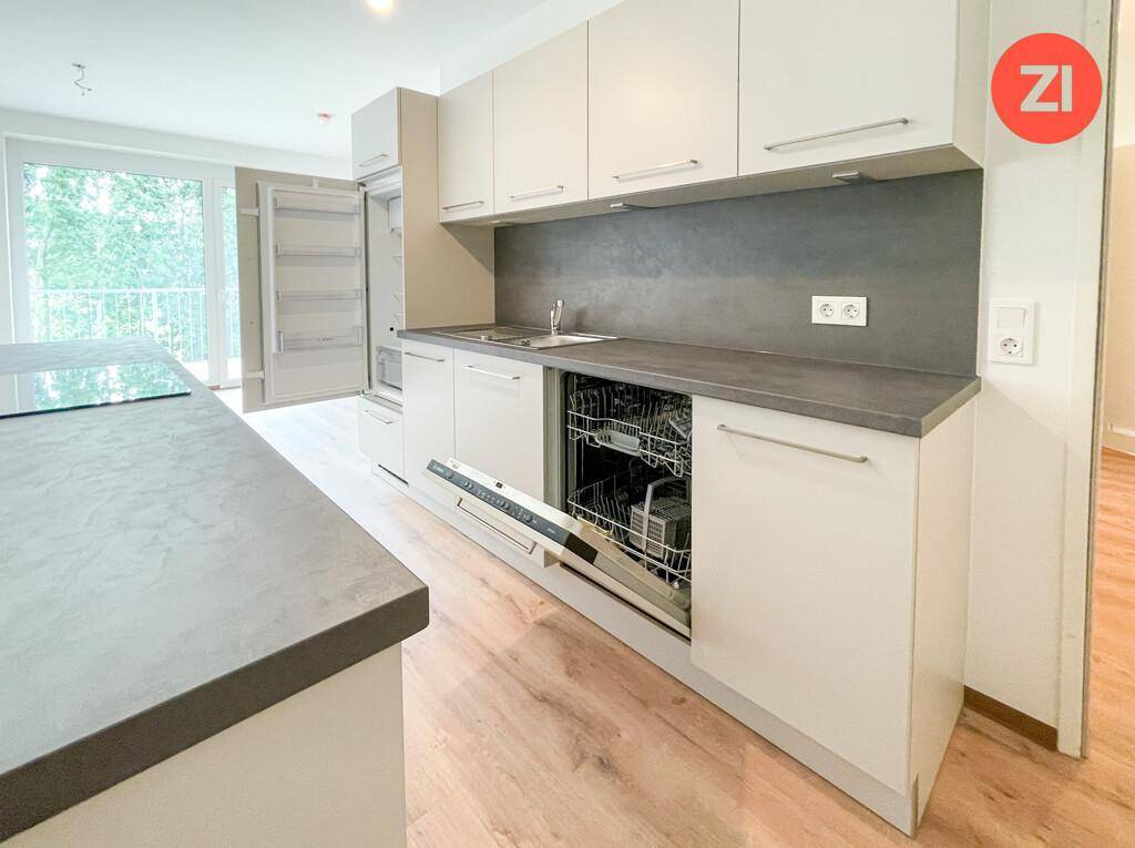 Helle Einbauküche mit integriertem Geschirrspüler, Kühlschrank und modernen Oberflächen.