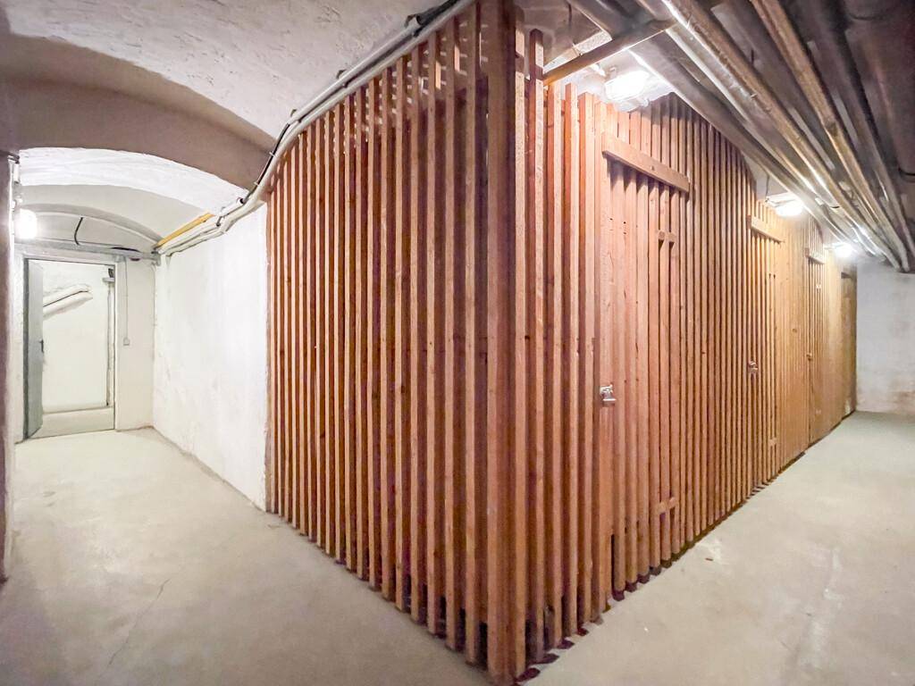 Kellerraum mit Holzverschlägen für Lagerzwecke und gewölbter Decke.