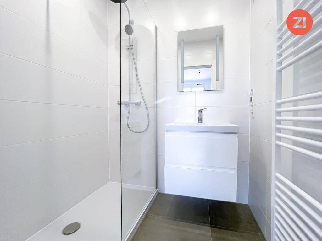 Modernes Badezimmer mit begehbarer Dusche, Einzelwaschbecken und beheiztem Handtuchhalter.