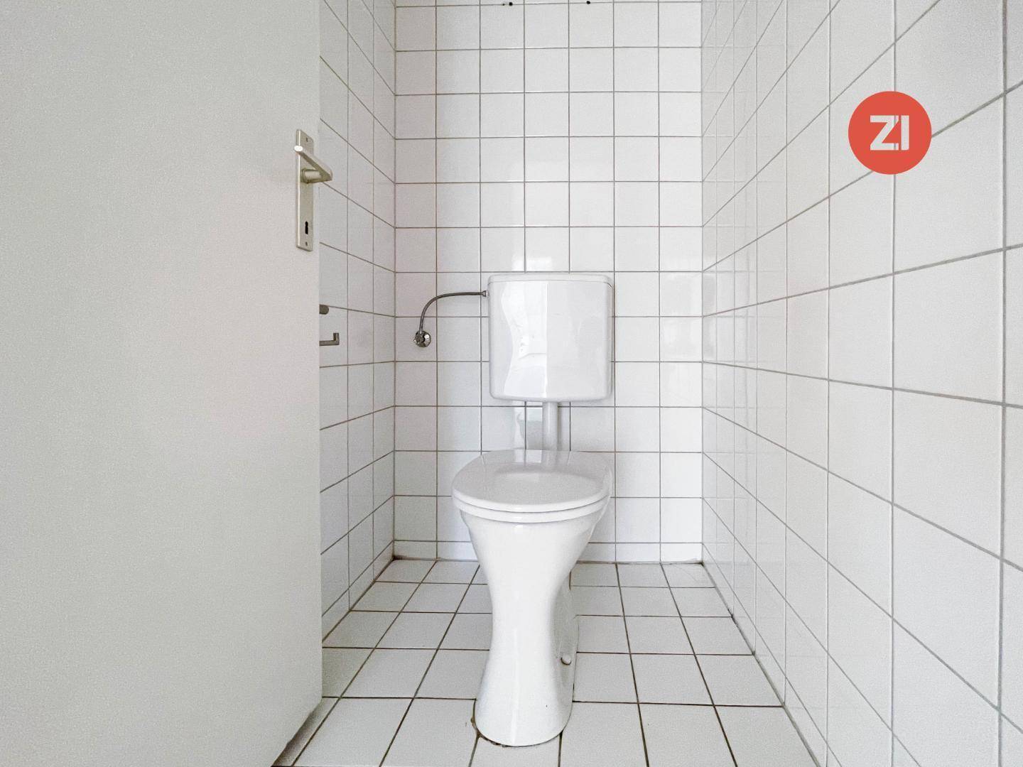 Kleines WC mit weißen Fliesen an Wänden und Boden, funktional und sauber gestaltet.