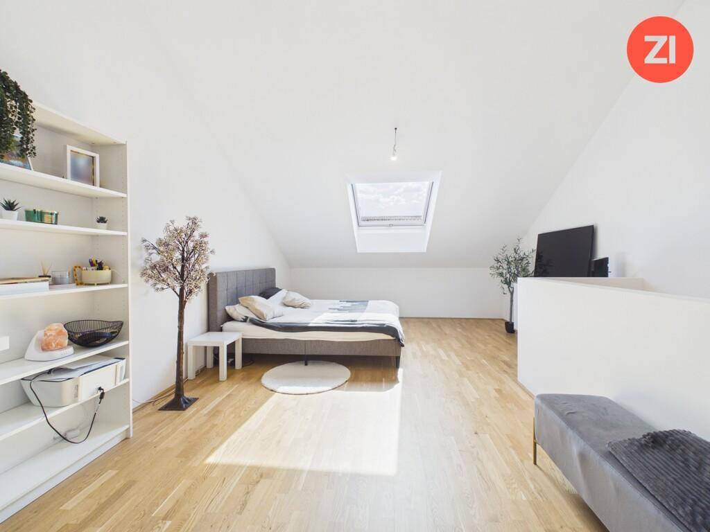 Geräumiges Schlafzimmer im Dachgeschoss mit Dachfenster, Holzboden und viel Tageslicht.