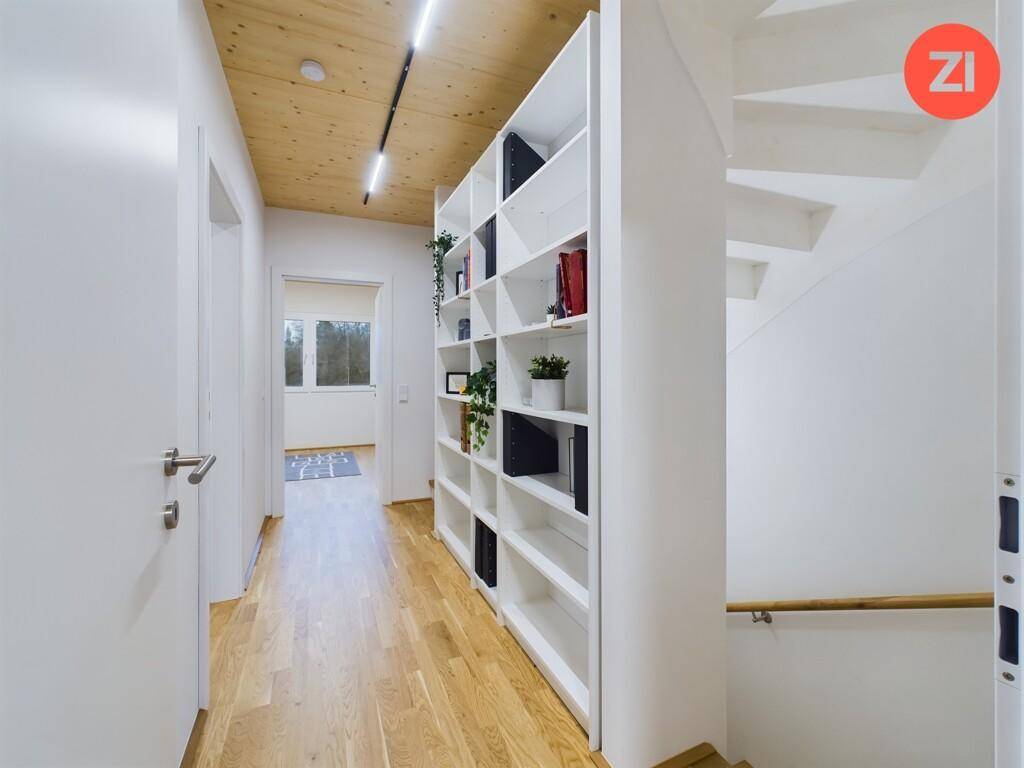Heller Flur mit integriertem Bücherregal, Holzfußboden und Treppenaufgang.