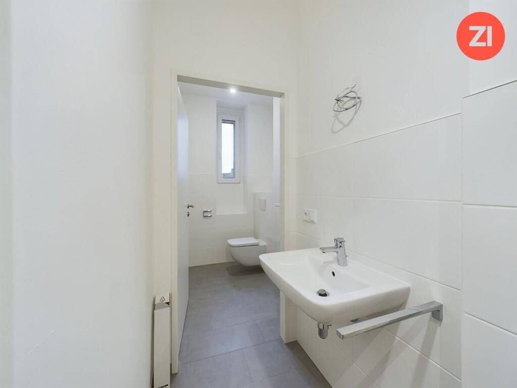 Helles Gäste-WC mit modernem Waschbecken und weiß gefliesten Wänden, praktisch und sauber.