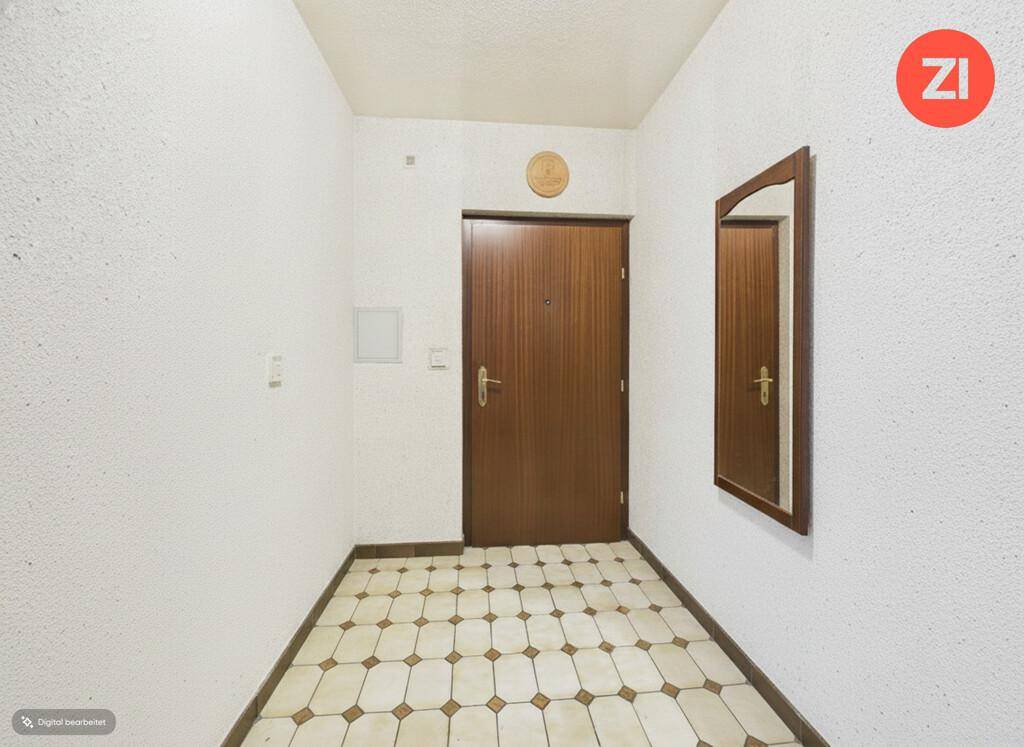 Funktionaler Eingangsbereich mit gemusterten Fliesen und einer Holztür.