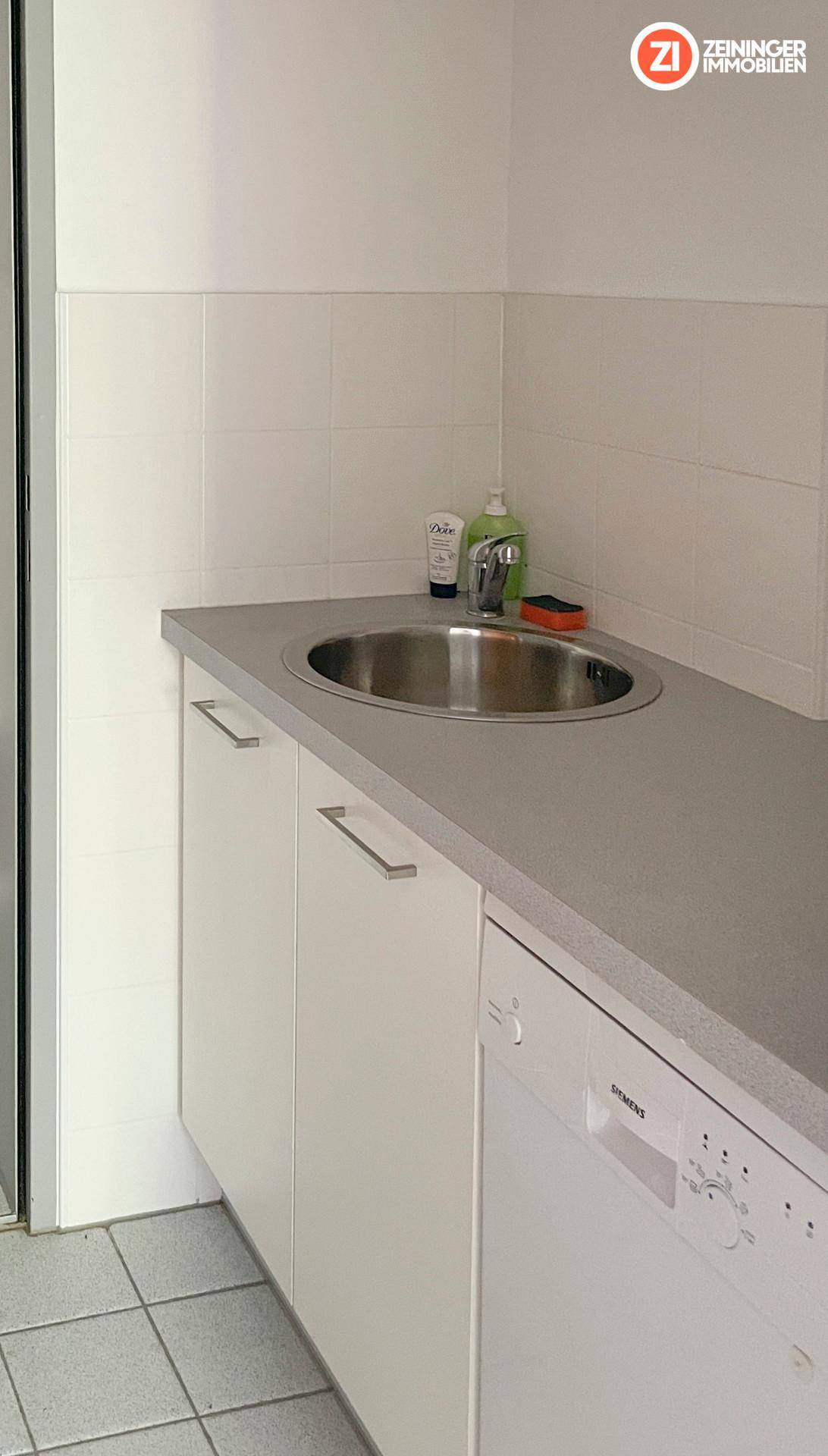 Kleine Küchenzeile mit Spülbecken, Arbeitsplatte und integriertem Siemens Geschirrspüler, ideal für Pausen.