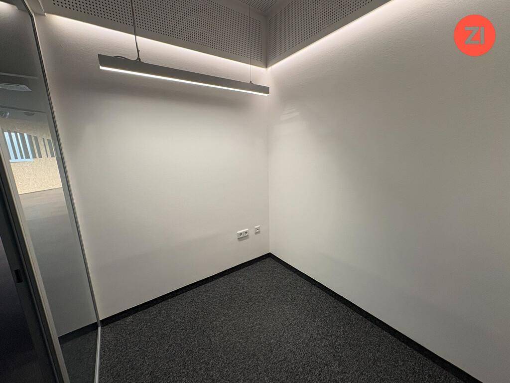 Kleiner, heller Büroraum mit Teppichboden und moderner Deckenbeleuchtung.