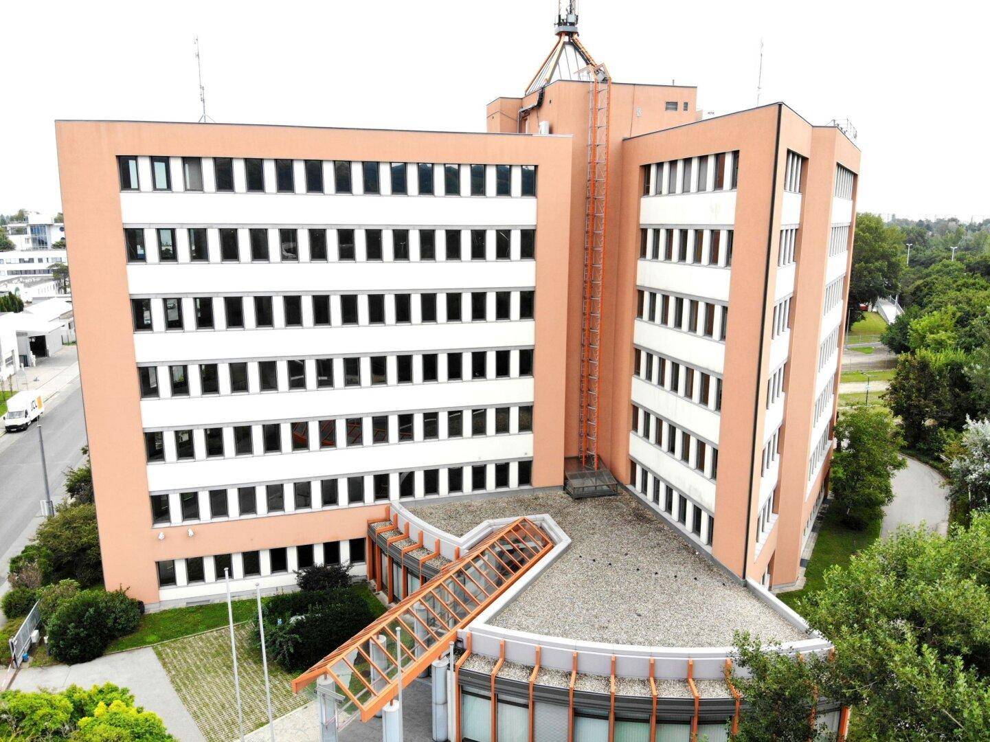 Modernes Bürogebäude mit markanter Architektur und vielen Fenstern in städtischer Umgebung.