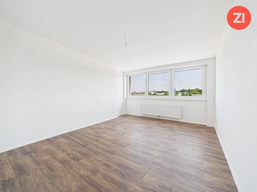 Geräumiges Schlafzimmer mit Laminatboden und breiten Fenstern, die viel Tageslicht hereinlassen.