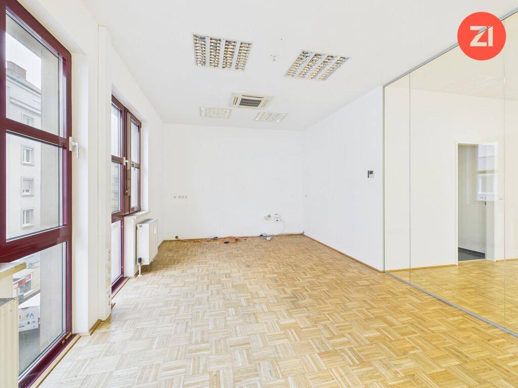Eckbereich des Büros mit großen Fenstern, die viel Tageslicht hereinlassen und einen Blick auf die Umgebung bieten.