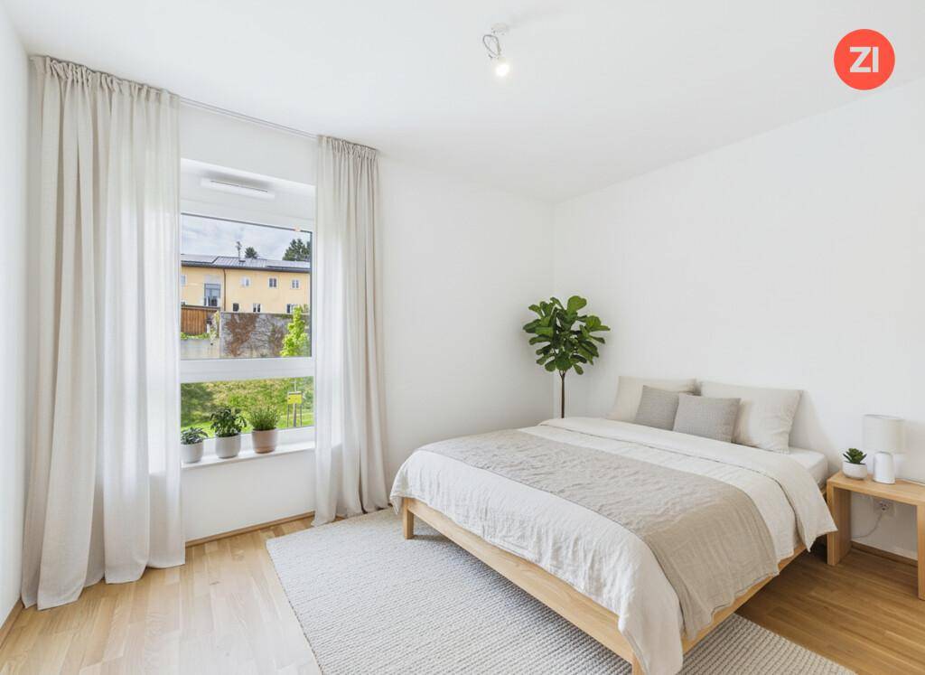 Gemütliches Schlafzimmer mit großem Fenster, hellem Holzboden und einer Zimmerpflanze.