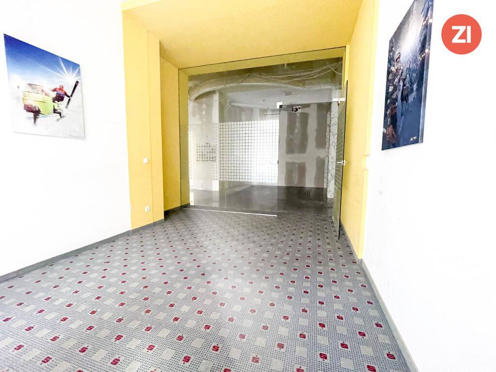 Heller Eingangsbereich mit gemustertem Boden und gelben Türrahmen, führt zu weiteren Räumen.