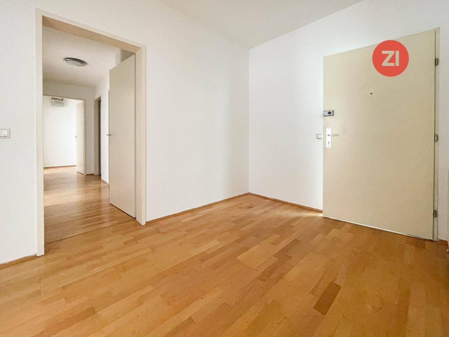 Eingangsbereich mit Holzboden und Zugang zu weiteren Räumen der Wohnung.