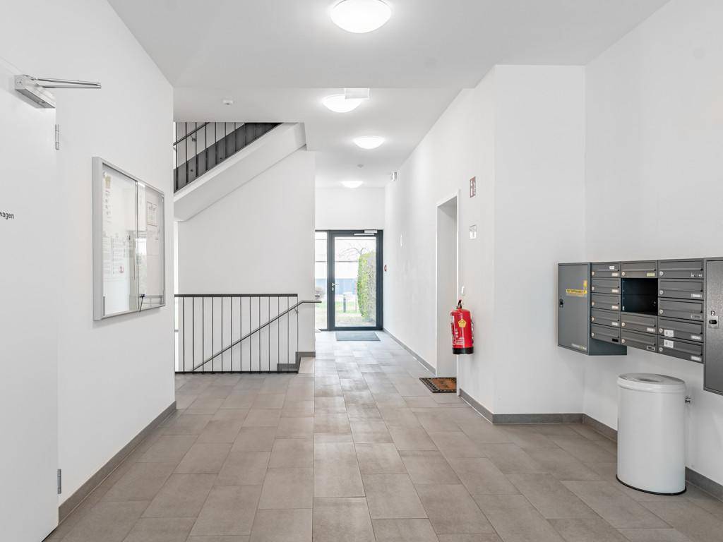 Eingangsbereich des Gebäudes mit Briefkästen, Fliesenboden und Zugang zum Treppenhaus.