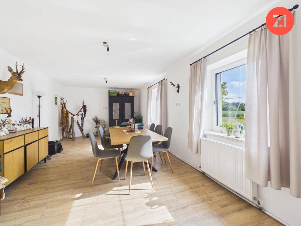 Geräumiger Essbereich mit Holzboden, großem Esstisch und traditioneller Dekoration.