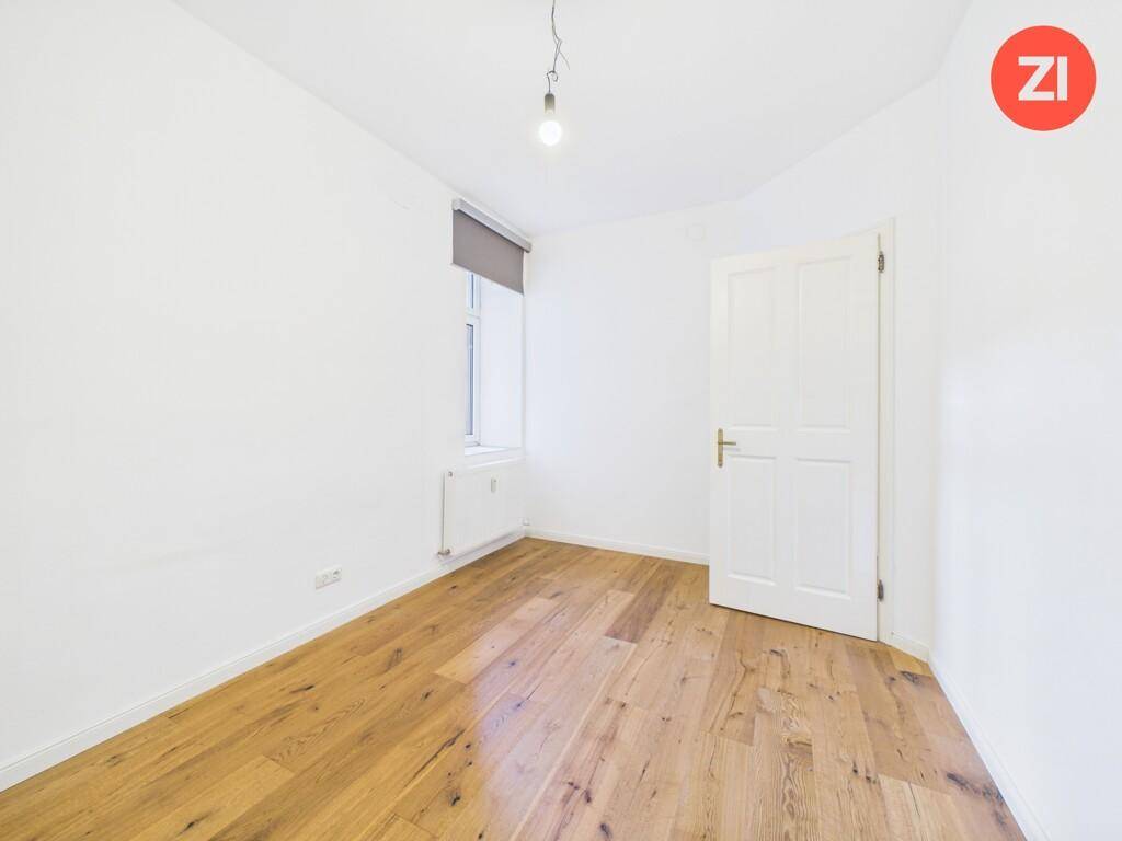 Ruhiges Schlafzimmer mit Holzboden und einem Fenster, bietet vielseitige Nutzungsmöglichkeiten.