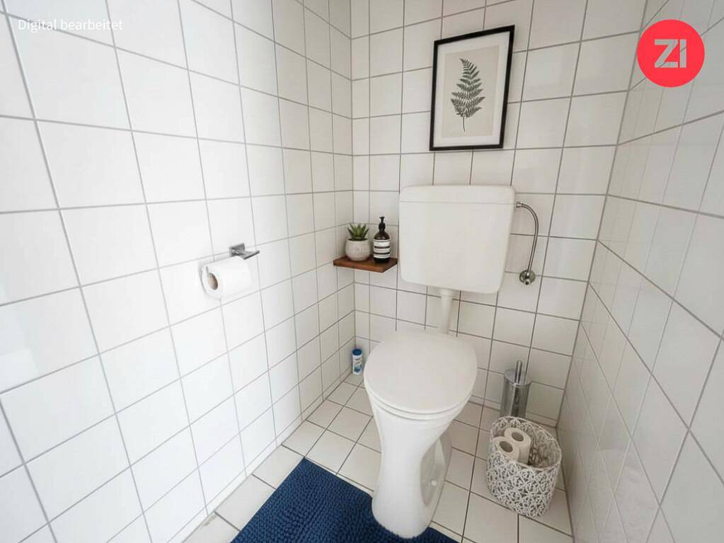 Modern gestaltetes Gäste-WC mit weißen Fliesen und minimalistischer Dekoration.
