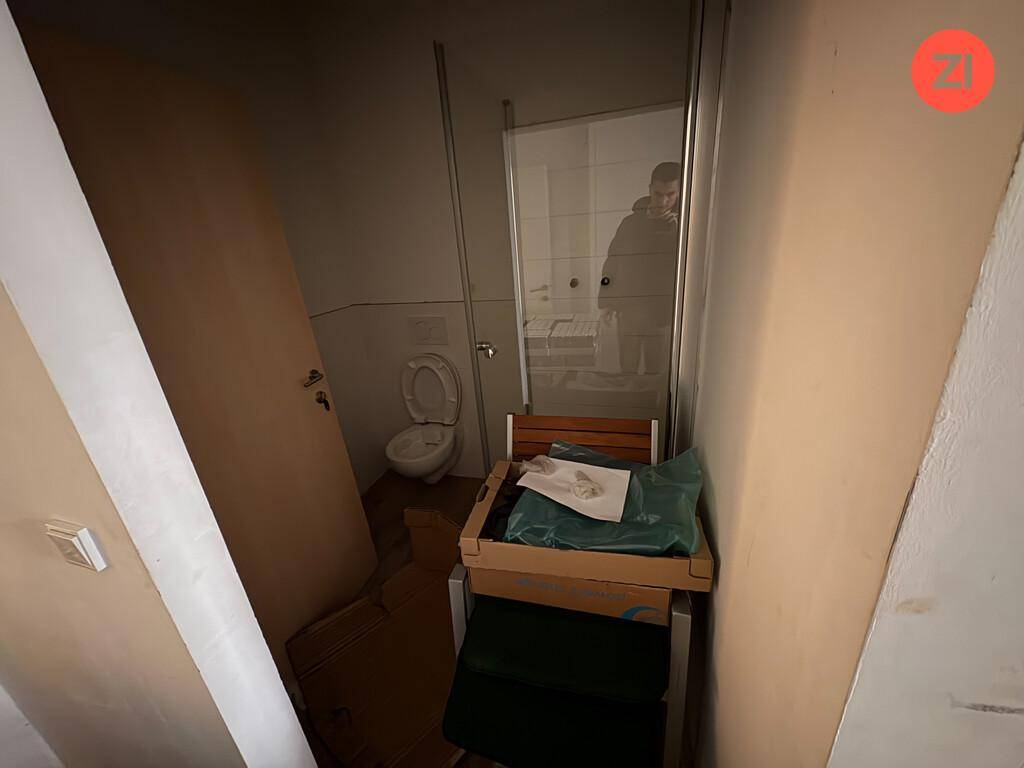 Kleiner Toilettenraum mit WC und Duschkabine, funktional und einfach ausgestattet.