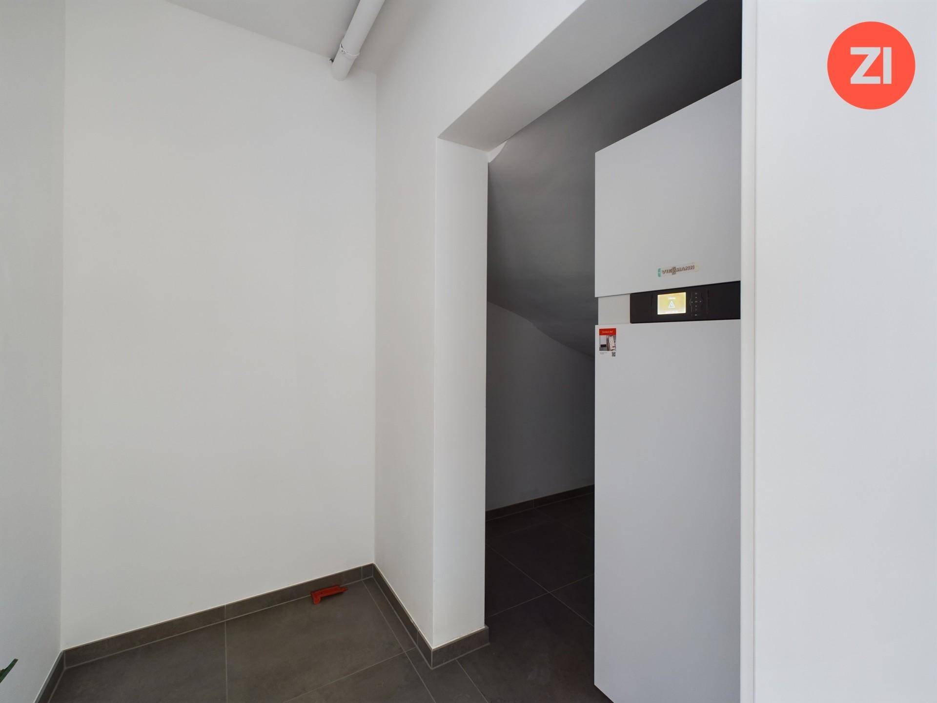 Kleiner Hauswirtschaftsraum mit Heizungsanlage und Fliesenboden, ideal für Technik und Lagerung.