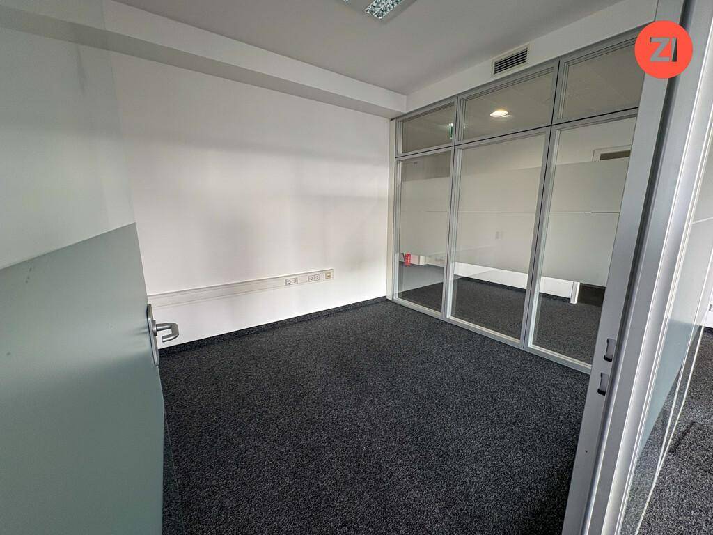 Büro mit Teppichboden und einer Glaswand, die den Raum abtrennt und für Transparenz sorgt.