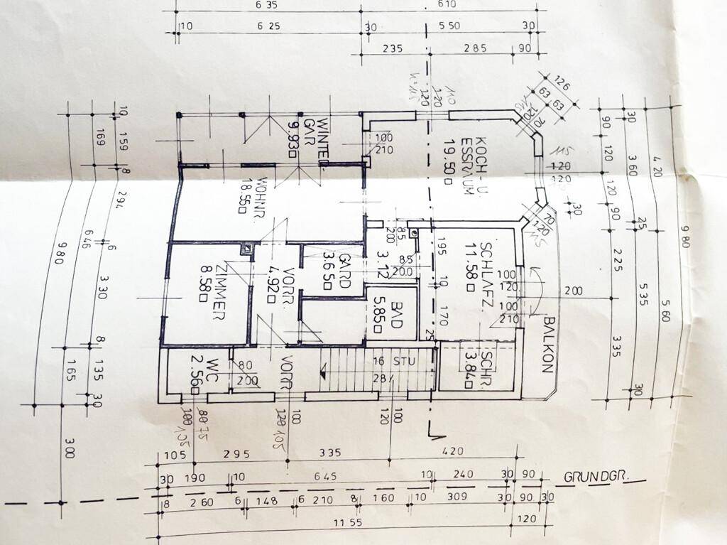 Grundriss des Erdgeschosses mit Wohnzimmer, Küche, Schlafzimmer und Balkon.