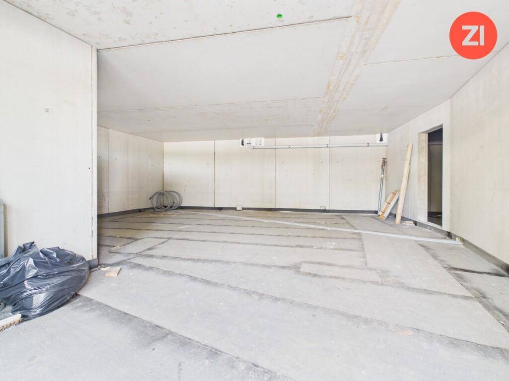 Großer, unfertiger Innenraum mit Betonwänden und -decken, bereit für den Ausbau.