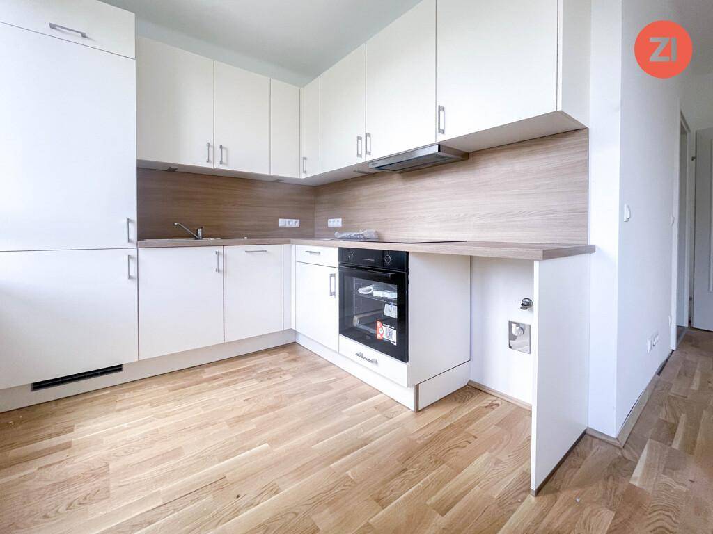 Moderne Einbauküche mit weißen Schränken, Holzoptik-Arbeitsplatte und integriertem Backofen.