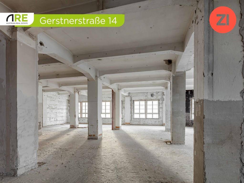 Offener Gewerberaum mit vielen Fenstern, Betonpfeilern und viel natürlichem Lichteinfall.